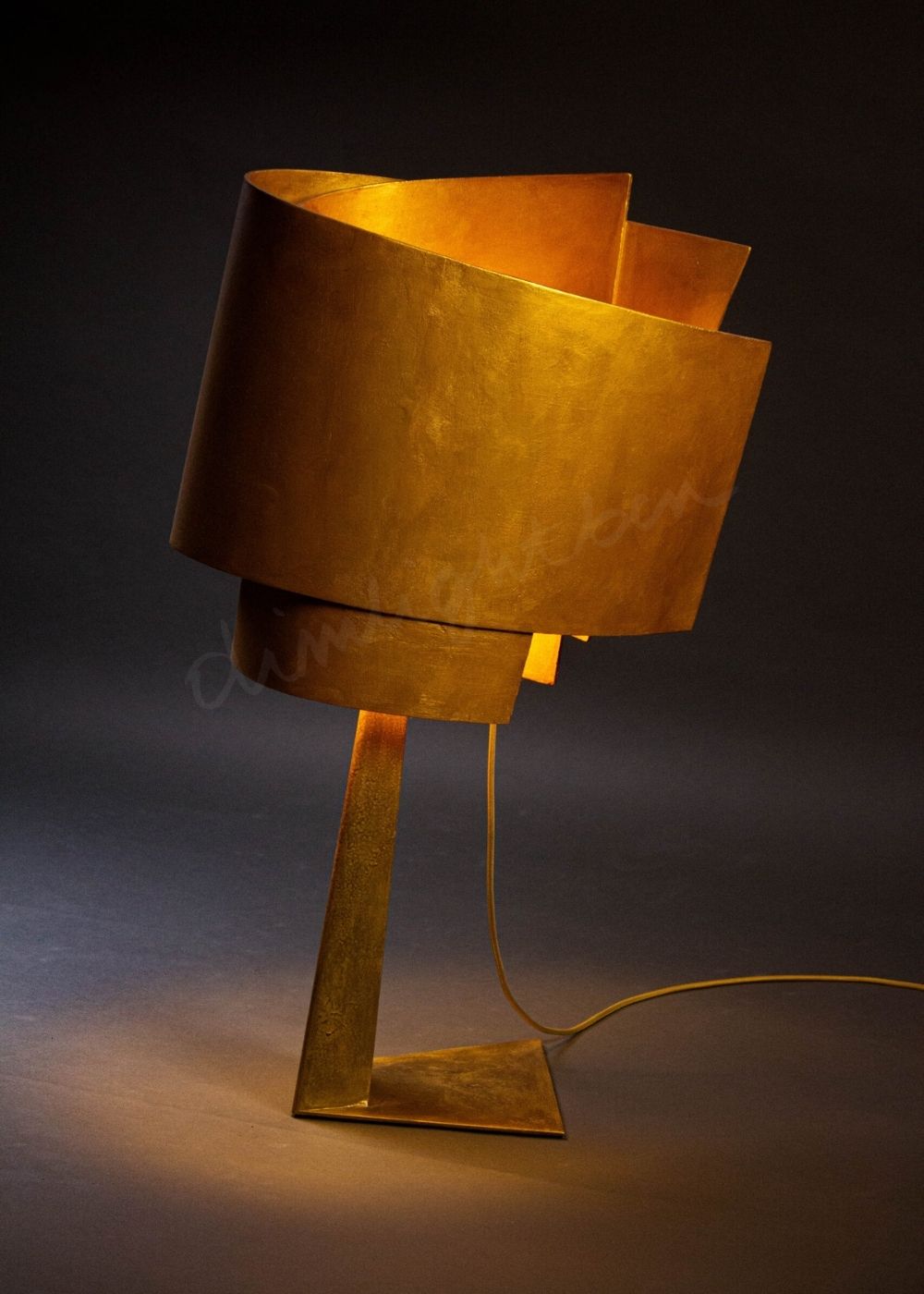 lámpara gugen escultura de luz sobremesa en hierro-okumen-dorado ángulo lateral luz cálida Dimlightbcn Marino Robles
